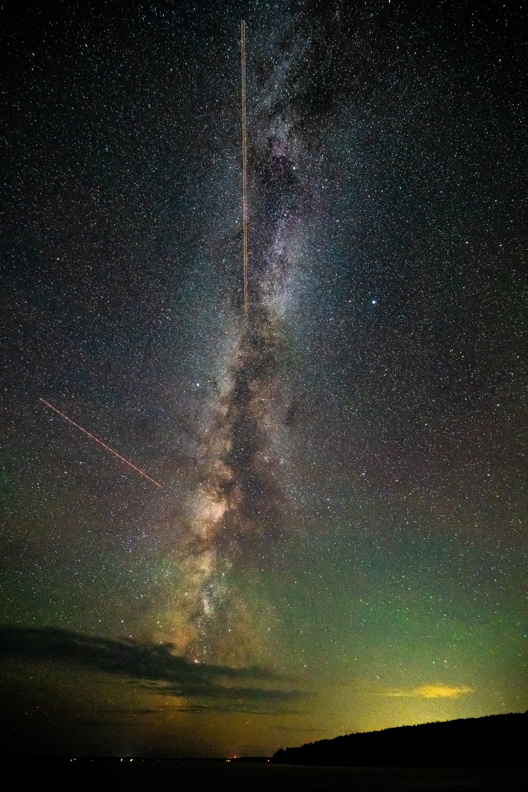 The Milky Way rising over Acadia National Park with meteor and satellite trails streaking past