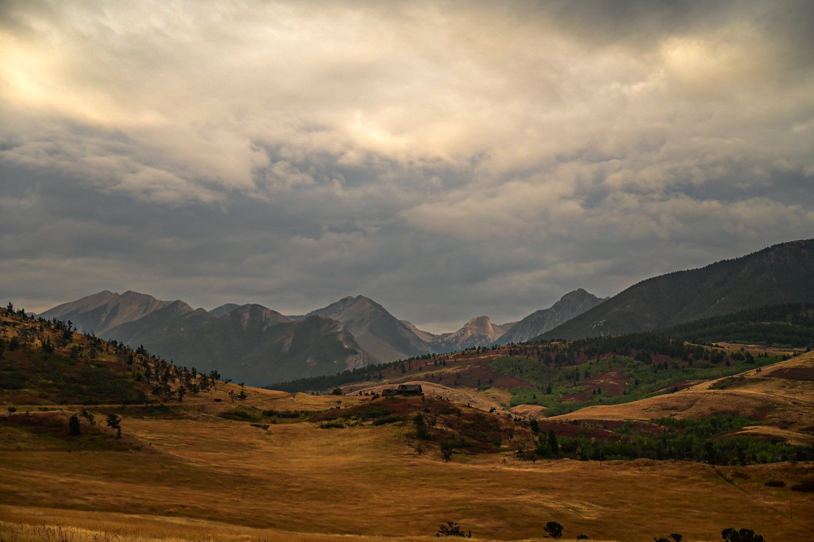 Storm light breaking over a mountain ranch valley in Montana